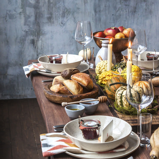 Rustic table setting with pumpkin soup and pumpkins on the background of the window in the loft