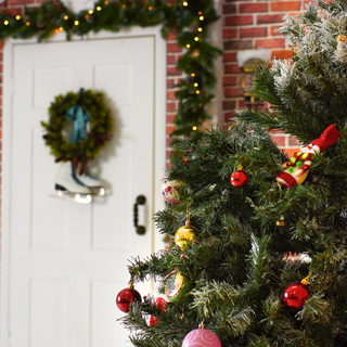 A decorated Christmas tree stands in the courtyard near the front door