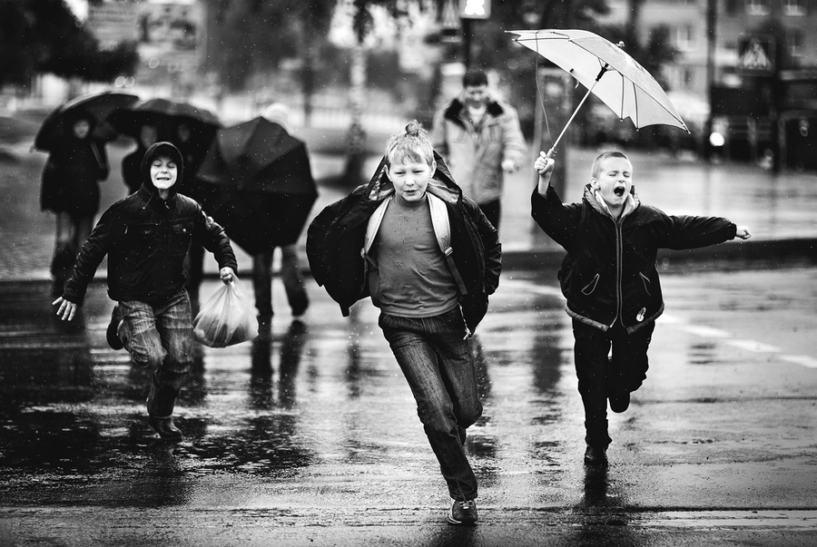 Дети перебагают улицу во время дождя