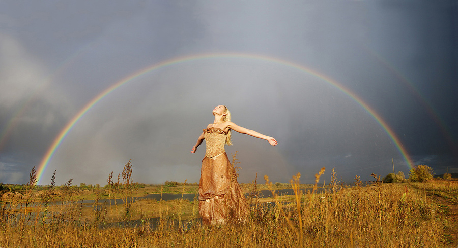 Девушка во время фотосессии под радугой,случайно возникшей после дождя