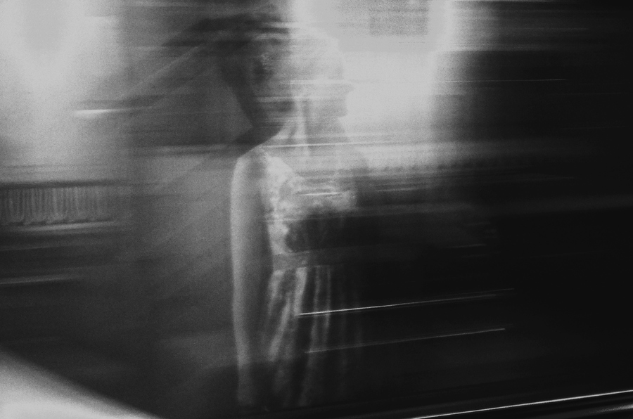 Отражение девушки в проходящем поезде метро