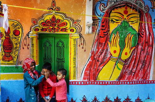 Дипанджан Чакраборти запечатлевает красочные рисунки на стенах домов в Калькутте 
