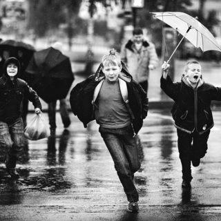 Дети перебагают улицу во время дождя
