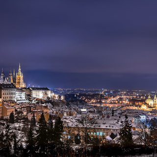 View of Prague Castle from Strahov monastery at night in winter with roofs covered with snow. Prague, Czech Republic