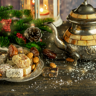 Oriental sweetness Turkish delight and rahat on the metal vintage plate with teapot in winter Christmas decoration on the wooden natural background.