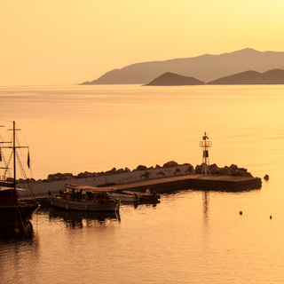 Sunrise. Early morning. Harbour with marine vessels, boats and lighthouse. Panoramic view from a cliff on a Bay with beach Bali - vacation resort, with secluded beaches and clear ocean waters, Rethymno, Crete, Greece