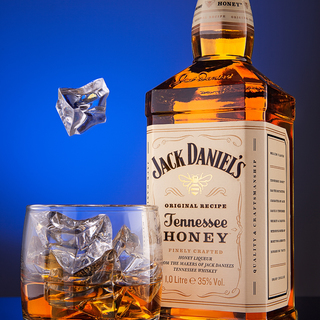 Whiskey Bottle Jack Deniels Tennessee Honey original recipe, and a glass of ice.