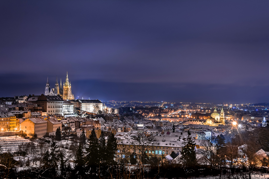 View of Prague Castle from Strahov monastery at night in winter with roofs covered with snow. Prague, Czech Republic