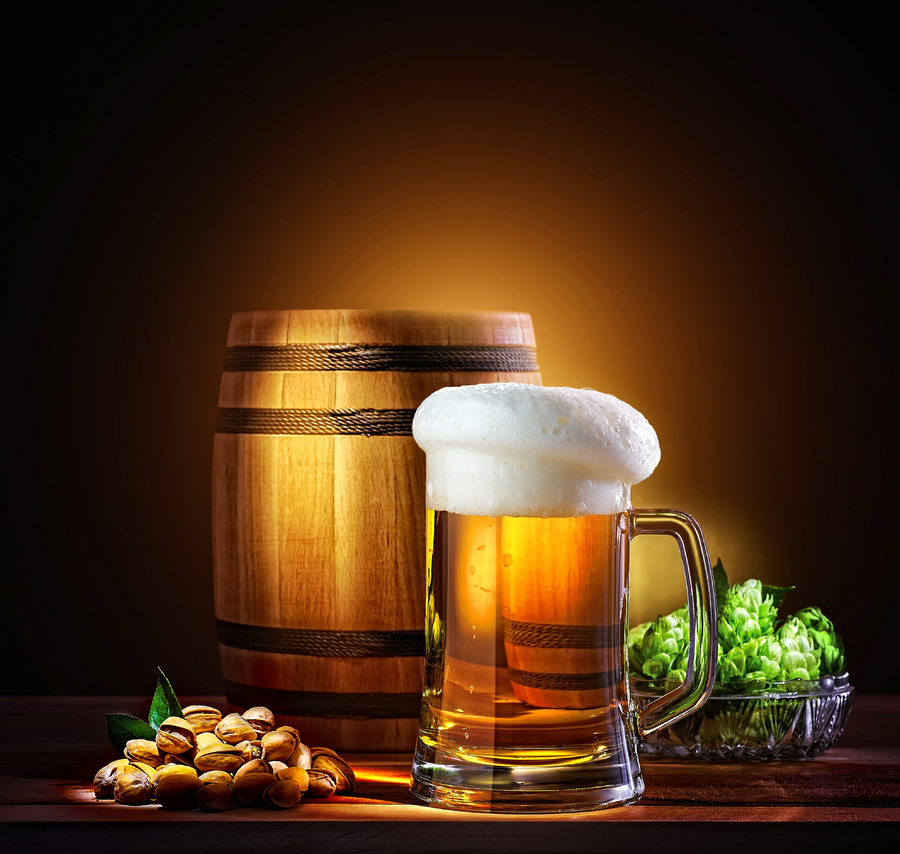 Beer barrel with beer glass on a wooden table. The dark background.