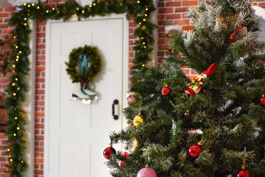 A decorated Christmas tree stands in the courtyard near the front door