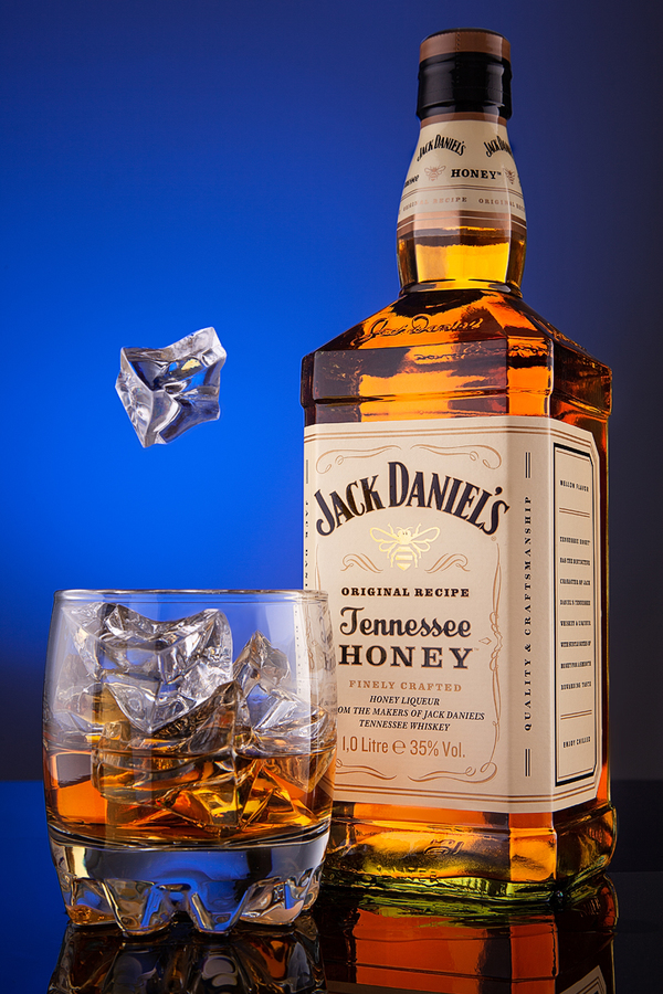 Whiskey Bottle Jack Deniels Tennessee Honey original recipe, and a glass of ice.