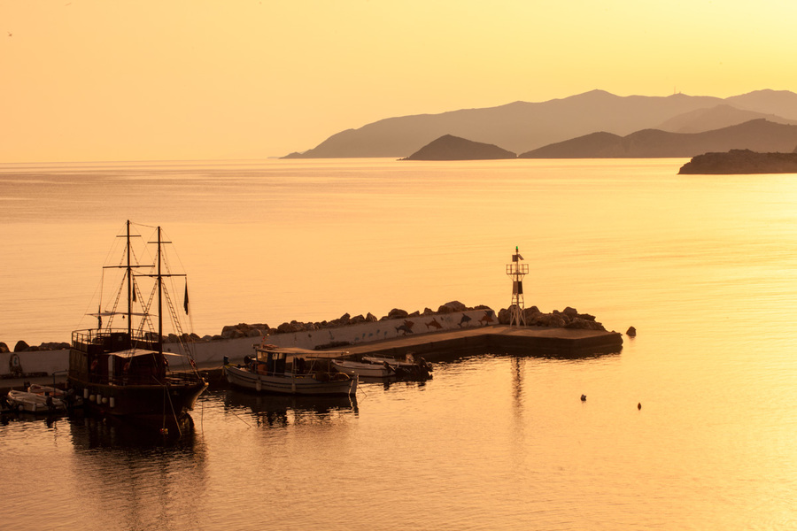 Sunrise. Early morning. Harbour with marine vessels, boats and lighthouse. Panoramic view from a cliff on a Bay with beach Bali - vacation resort, with secluded beaches and clear ocean waters, Rethymno, Crete, Greece